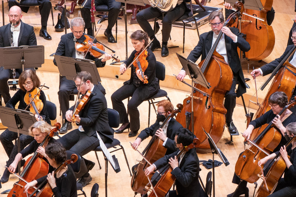 Musicians sitting in arched rows playing cellos, violas, and violins